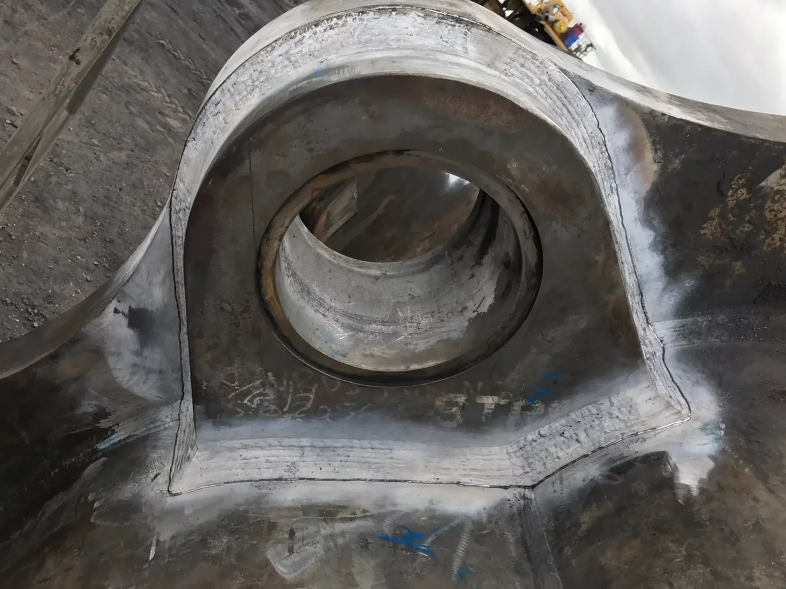 Treated welds around a bearing boss on a heavy machine arm