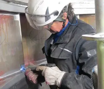 Operator treating welds with a HiFIT tool